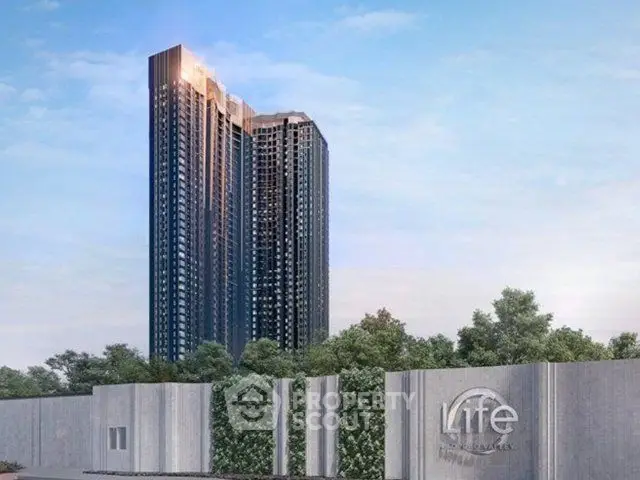 Stunning high-rise building with modern architecture and lush greenery at Life Asoke Rama 9.