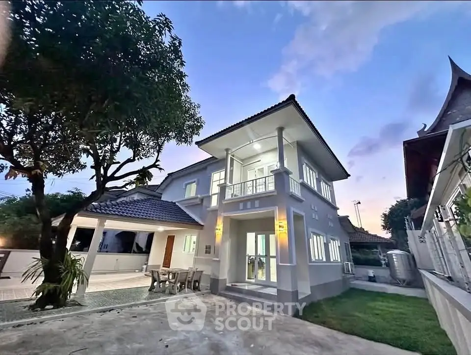 Charming two-story house with spacious driveway and lush garden at dusk