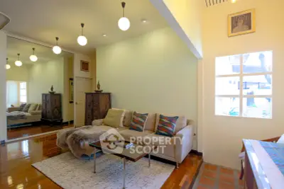 Charming living room with cozy sofa, elegant lighting, and polished wooden floors in a stylish home.