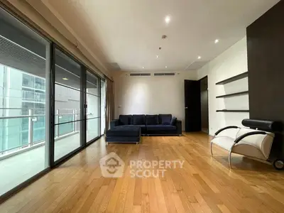 Spacious modern living room with hardwood floors and balcony access