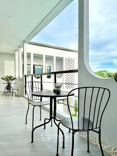 Modern balcony with stylish seating and scenic view, perfect for relaxation and entertainment.