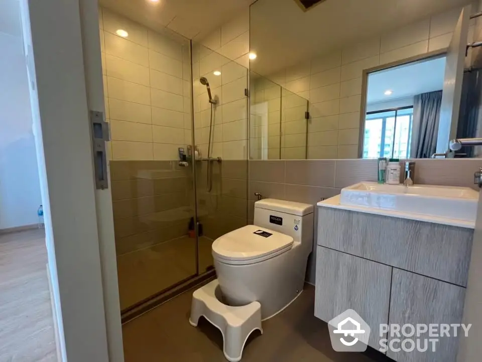 Modern bathroom with glass shower and sleek vanity in contemporary apartment