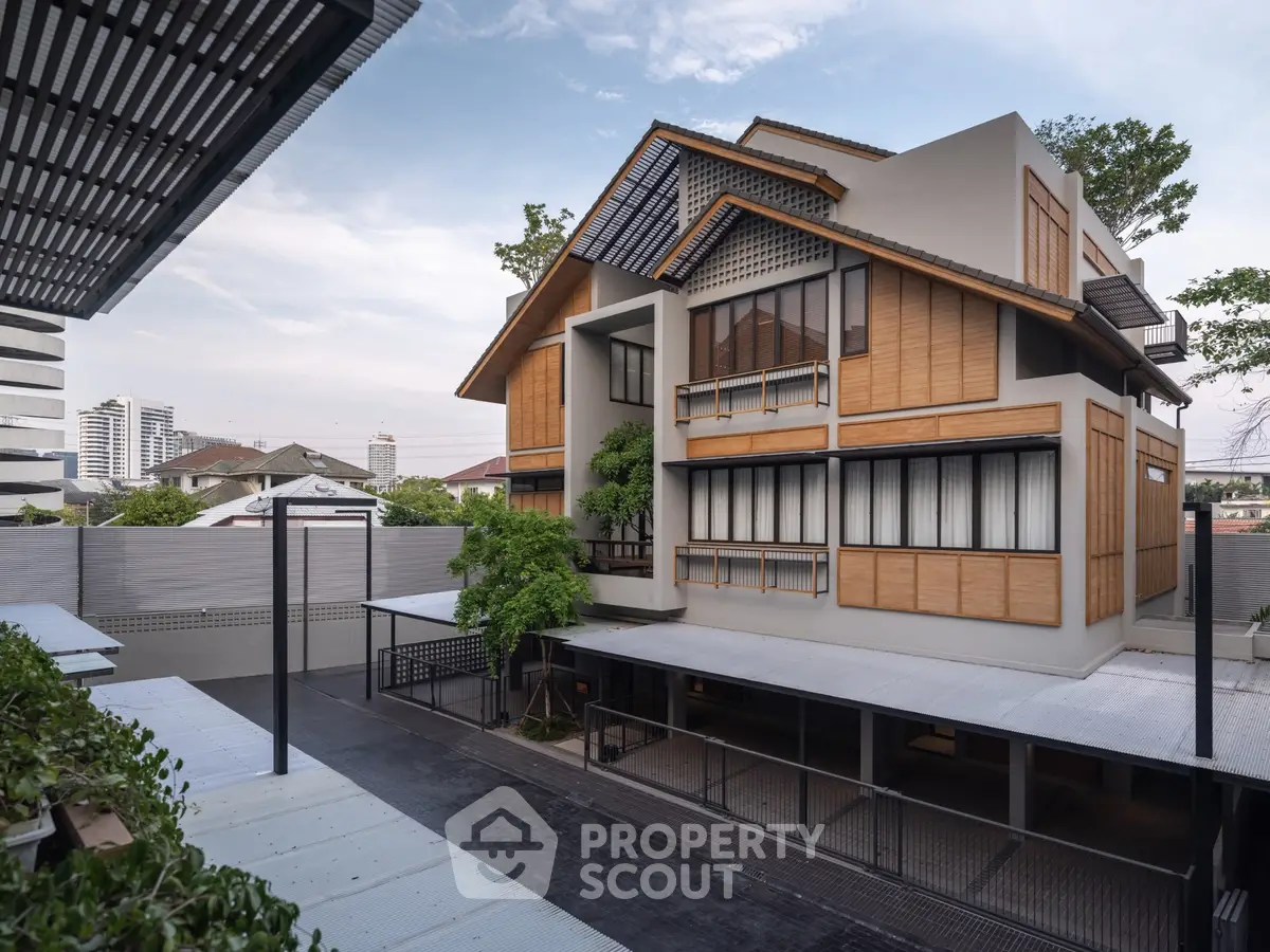 Modern multi-story building with unique architectural design and spacious outdoor area.