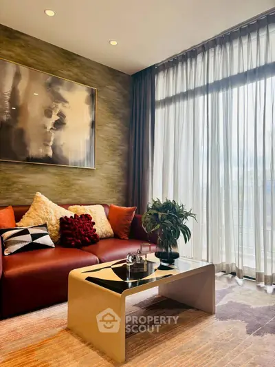 Stylish living room with modern decor, large window, and cozy seating area.