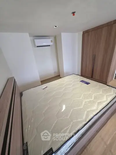 Modern bedroom with built-in wardrobe and air conditioning in a stylish apartment.