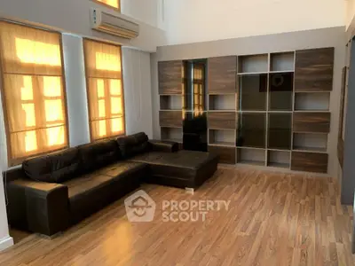 Spacious living room with modern leather sofa and elegant wooden flooring