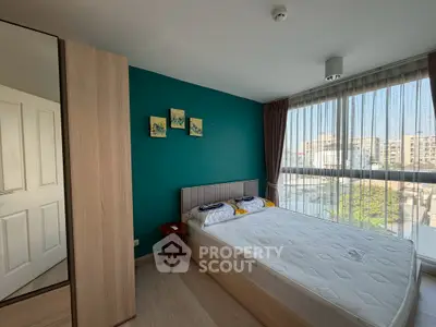 Bright bedroom with large window and modern decor in urban apartment