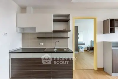 Modern kitchen with sleek cabinetry and open layout adjacent to bedroom