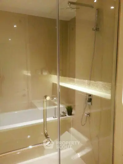 Luxurious bathroom with modern shower and bathtub in elegant beige tones.