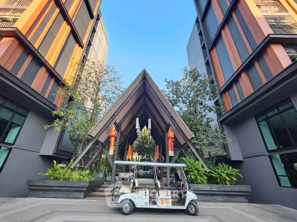 Modern building entrance with unique architecture and lush greenery