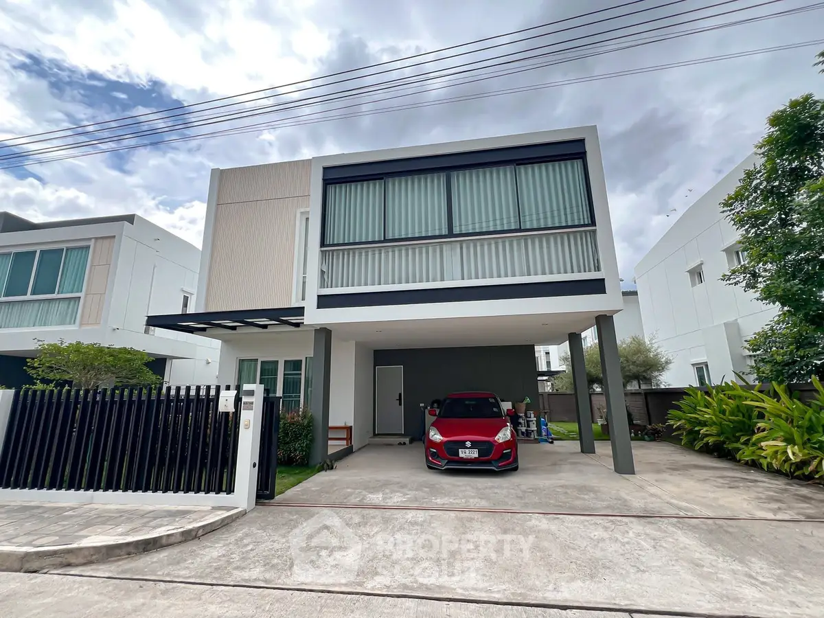 Modern two-story house with carport and sleek architectural design in a suburban neighborhood.