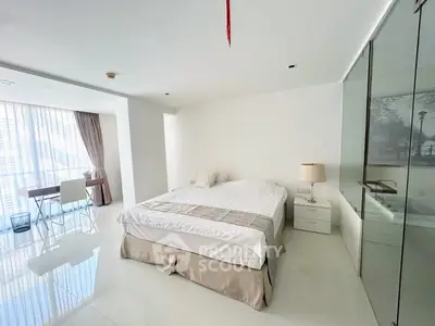 Spacious modern bedroom with large windows and sleek furnishings in a luxury apartment.