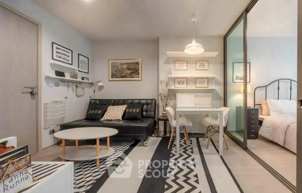 Modern living room with stylish decor and adjacent bedroom in open layout apartment.
