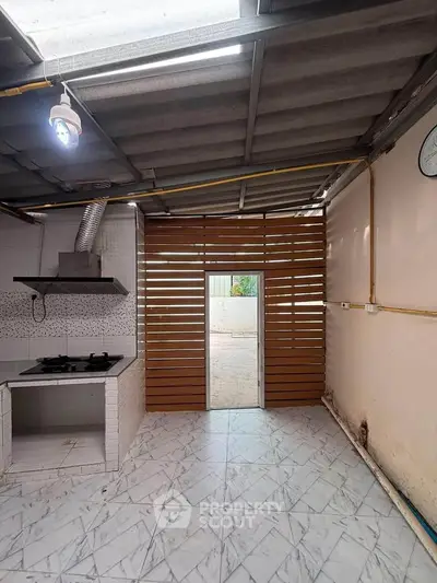 Modern kitchen with gas stove and unique wooden slat door design