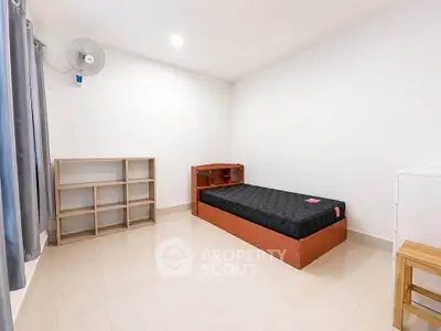 Minimalist bedroom with single bed and shelving in a bright, airy space.