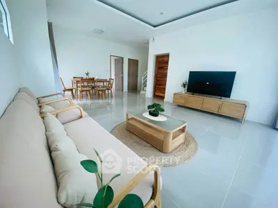 Spacious modern living room with sleek furniture and open dining area.