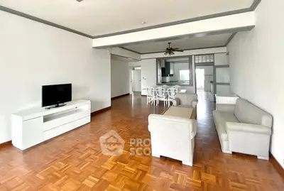 Spacious open-plan living room with elegant parquet flooring and modern furniture.