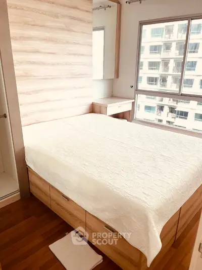 Modern bedroom with wooden flooring and large window offering city view