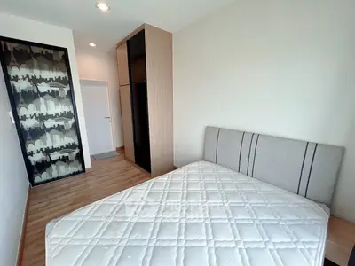 Modern bedroom with stylish decor and ample natural light, featuring a comfortable bed and sleek wardrobe.