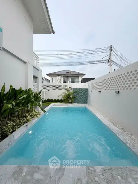 Luxurious private pool in modern residential backyard with elegant landscaping.