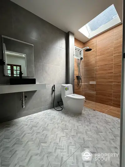 Modern bathroom with skylight, sleek fixtures, and elegant tile design