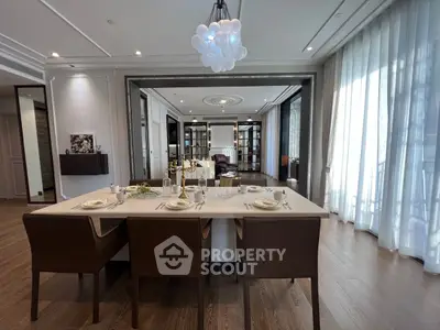 Luxurious open-plan dining and living area with elegant decor and large windows.