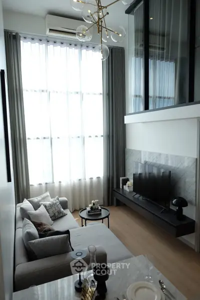 Modern living room with high ceilings, large windows, and stylish decor in a luxury apartment.