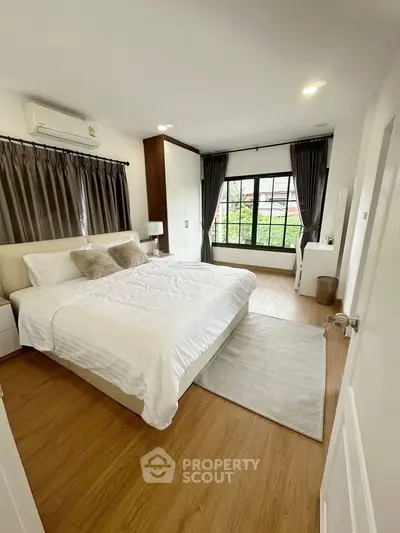 Spacious bedroom with large window and modern decor