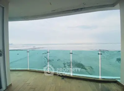 Stunning oceanfront balcony with panoramic sea views and glass railing.