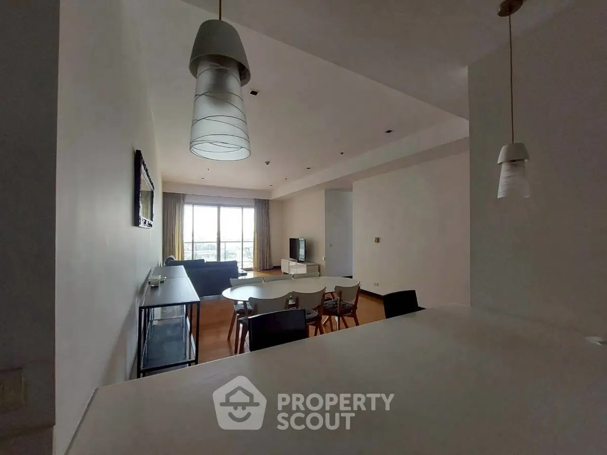 Spacious living room with modern lighting and large window view