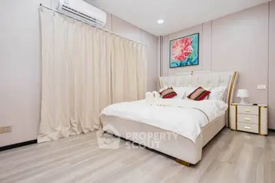 Elegant bedroom with modern decor and cozy ambiance, featuring a plush bed and stylish artwork.