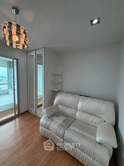 Cozy living room with modern lighting and comfortable seating in a stylish apartment.