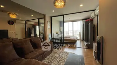 Modern living room with cozy brown sofa and glass partition leading to a bright bedroom with balcony view.