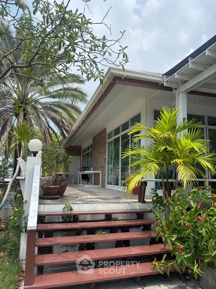 Charming tropical home with lush garden and inviting entrance, perfect for serene living.