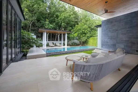 Luxurious outdoor patio with pool and lush greenery, perfect for relaxation and entertaining.