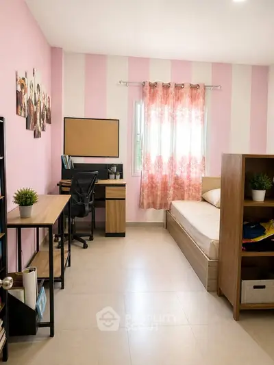 Charming bedroom with pink striped walls, cozy bed, and functional study area, perfect for a comfortable living space.