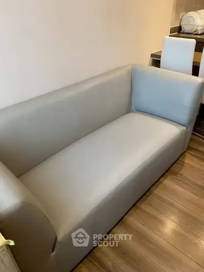 Modern living room with sleek gray sofa and wooden flooring, perfect for contemporary interiors.