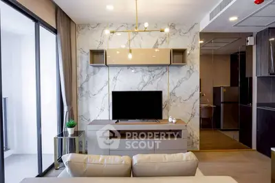 Modern living room with marble accent wall and sleek furniture in a stylish apartment.
