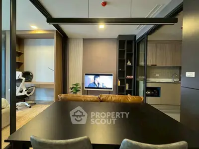 Modern open-plan living room with sleek kitchen and study area, featuring contemporary furniture and stylish decor.