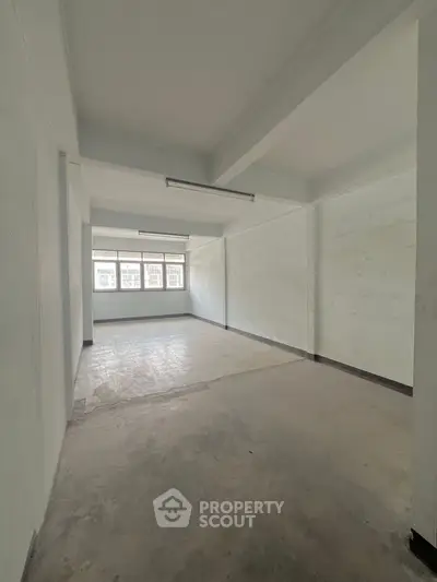 Spacious empty room with large windows and natural light, ideal for customization.