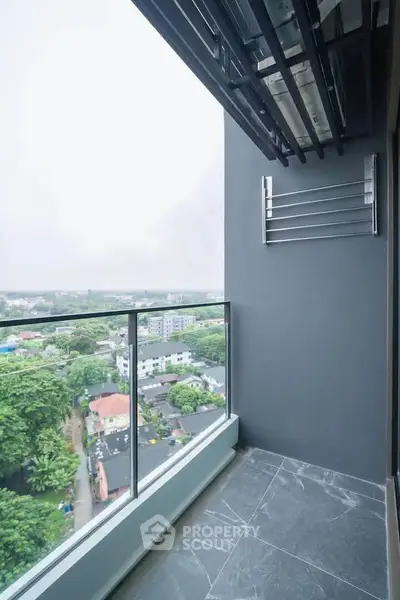 Modern balcony with glass railing offering panoramic city views in a high-rise apartment.