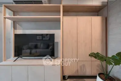 Modern living room with sleek wooden cabinetry and flat-screen TV, perfect for stylish urban living.