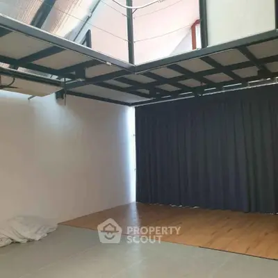 Spacious modern room with high ceiling and large windows, perfect for creative studio or office.