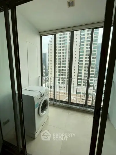 Modern apartment balcony with washing machine and city view, perfect for urban living.