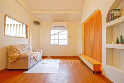 Cozy living room with modern decor and natural light, featuring a comfortable sofa and stylish wooden accents.