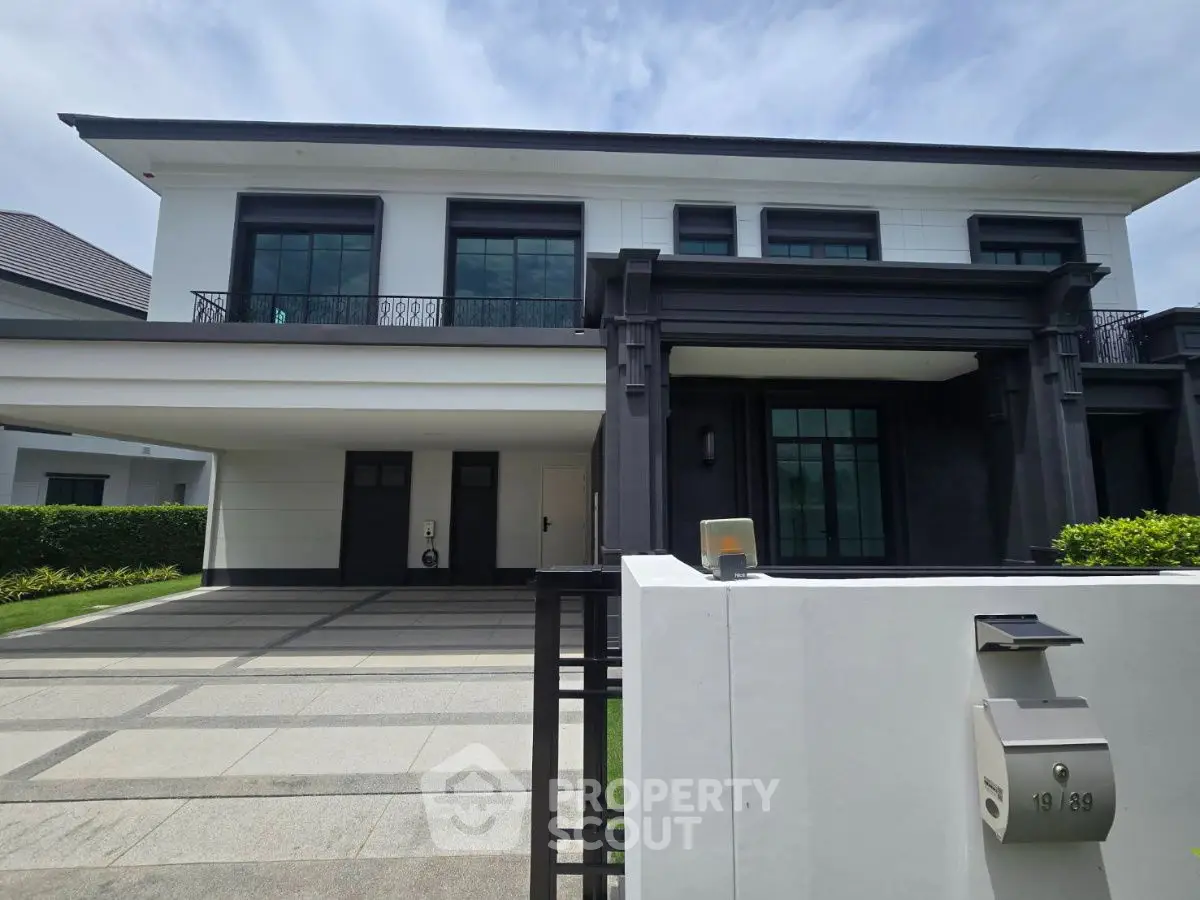 Luxurious modern two-story house with spacious driveway and elegant facade.