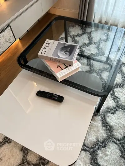 Modern living room with stylish glass coffee table and plush rug, perfect for contemporary interiors.
