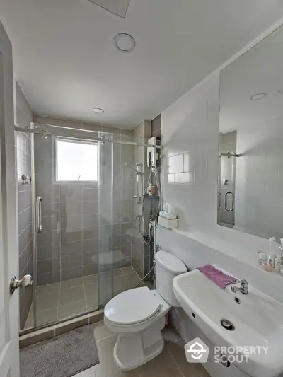 Modern bathroom with glass shower and sleek fixtures in a contemporary home.