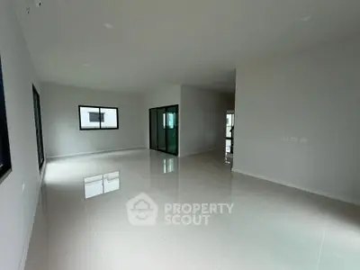 Spacious modern living room with large windows and glossy tiled floors