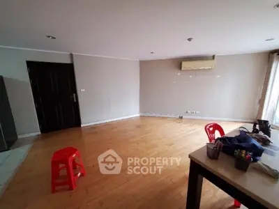 Spacious empty living room with wooden flooring and air conditioning